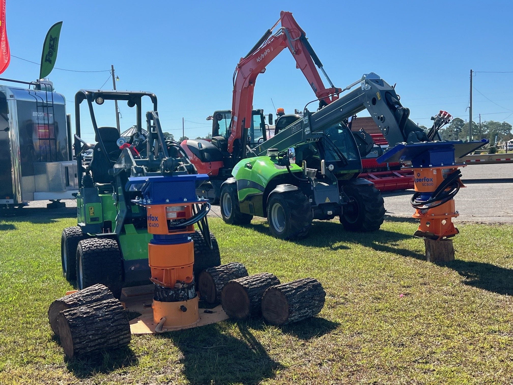 Dipperfox stump drill demo setup at an outdoor expo.